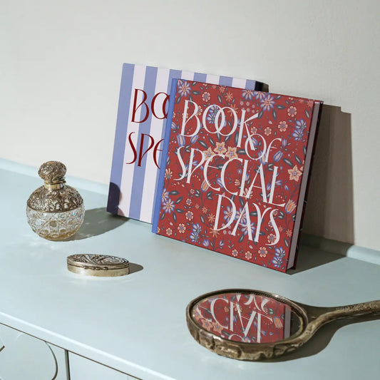 A Book of Special Days open on a desk beside a pen — a physical memory book designed as an intentional alternative to digital photo storage